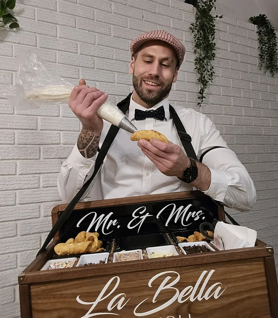 Chef preparing and piping fresh cannoli for La Bella Cannoli.